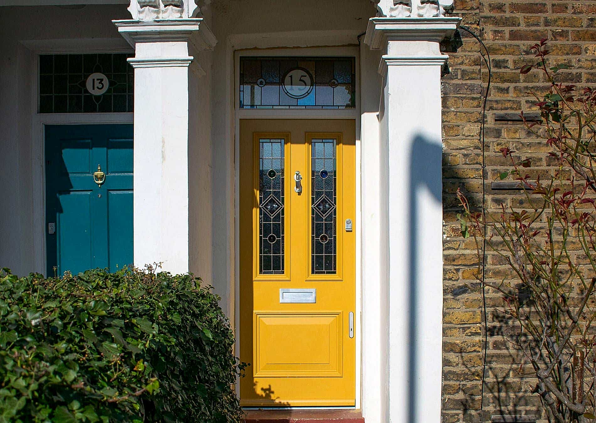Victorian front door and fanlight frame. Door spray painted bright yellow. Stained glass in door and fanlight.